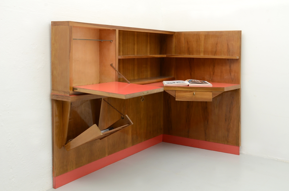 Parete arredata angolare con scomparto chiuso, portariviste, ripiani e piano scrittoio con formica rossa 1950
