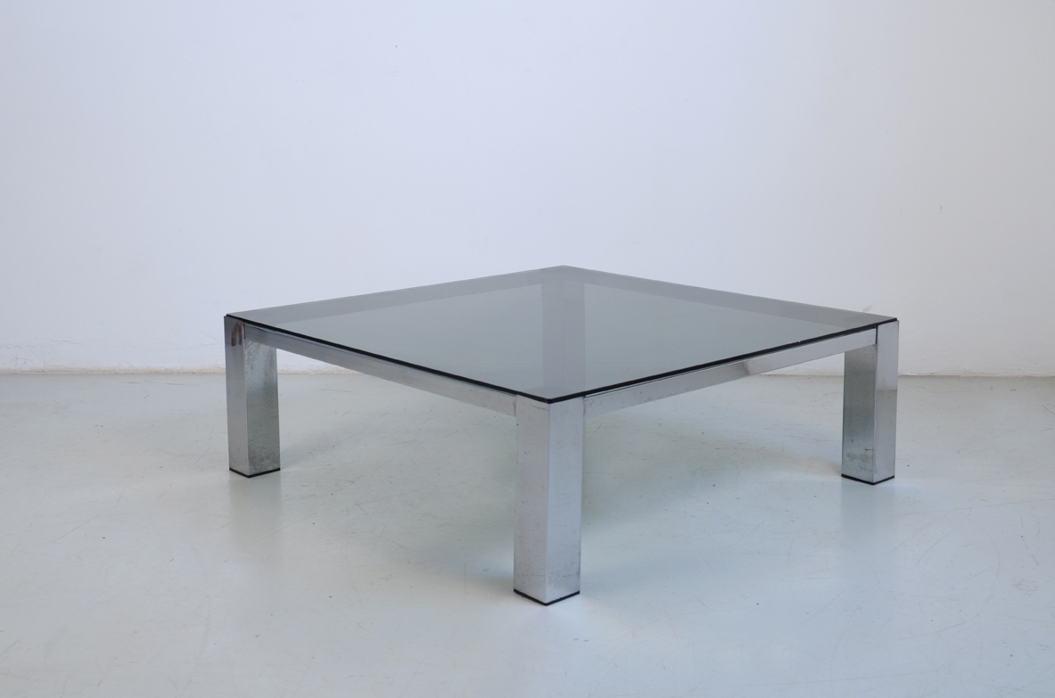 Large coffee table with metal structure and square glass top. 1960ca.