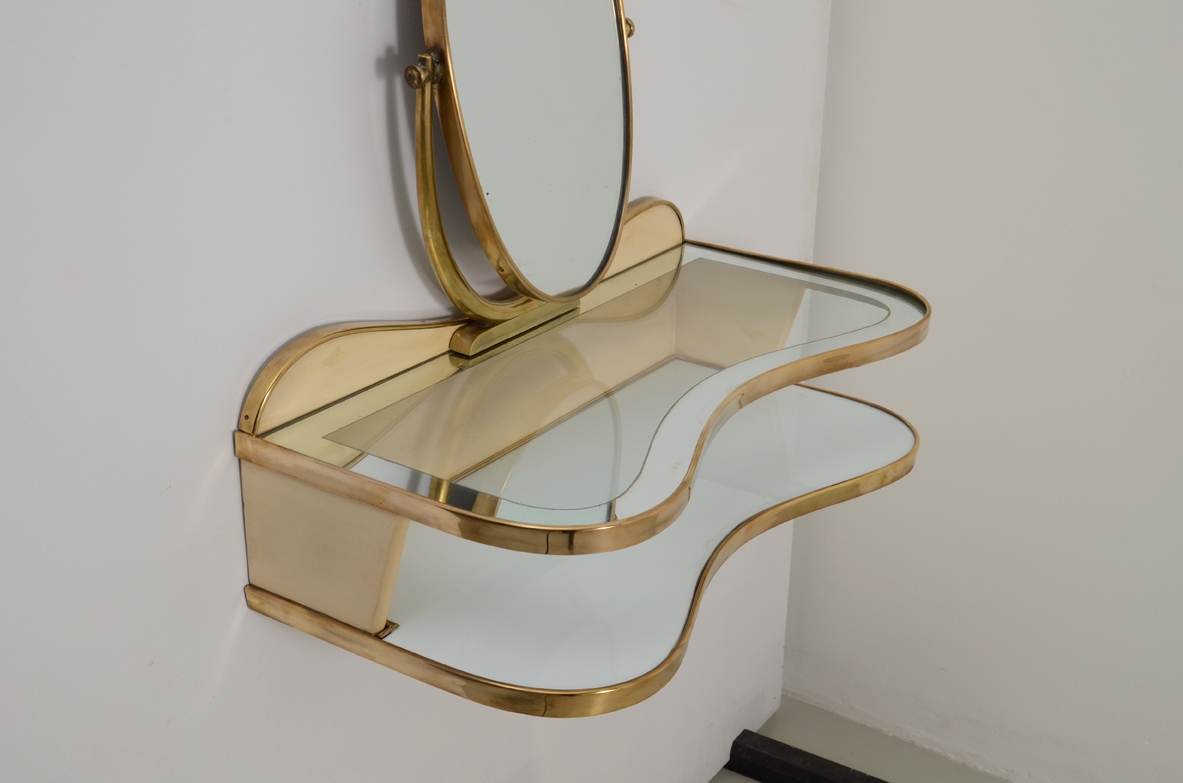 Gio Ponti, rare hanging console table in lacquered wood and brass with two shelves, one in mirrored glass and one in white opaline. Adjustable oval mirror on top. Provenience Cellina/Bormioli private collection. Gio Ponti Archive ref. Nr 16089.