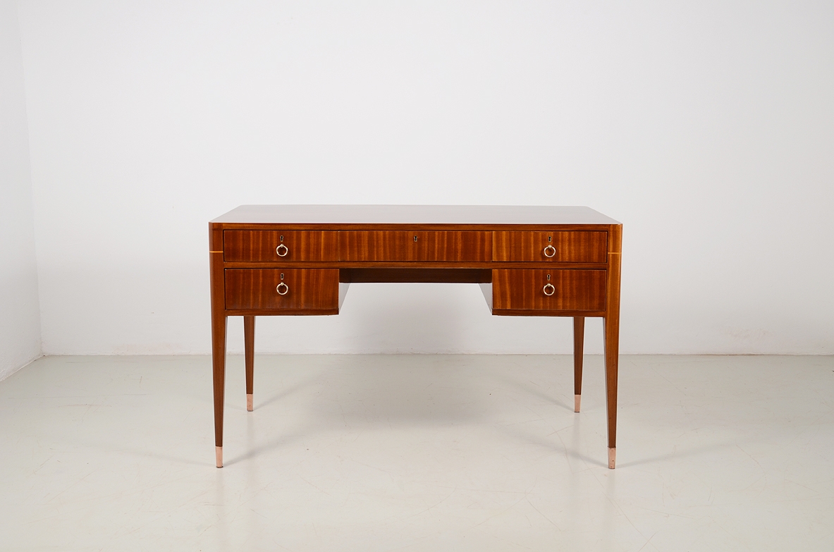 Italian elegant and curved 1950's desk in walnut and maplewood with five drawers and brass tips.