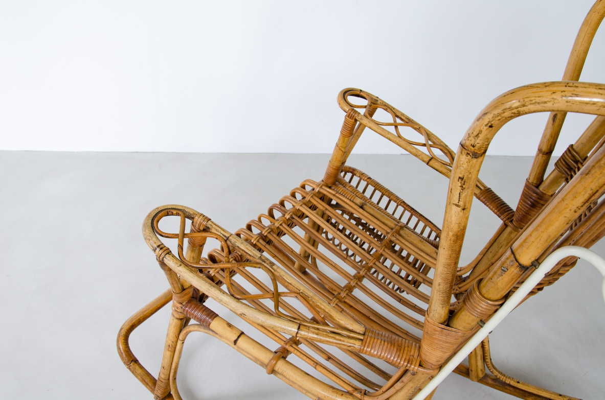 Sedia a dondolo in giunco con portariviste e lampada in metallo laccato. La lampada è applicata alla struttura mediante un tubo in metallo sagomato su misura originale dell epoca.  Prod. Bonacina anni 50'.
