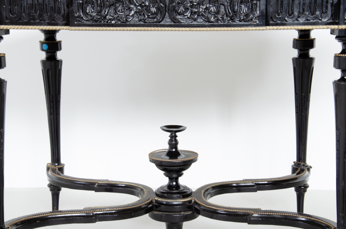 Tavolo da centro in legno ebanizzato con sottili gambe tornite e piano sagomato, profili in ottone. Francia, 1870-1900