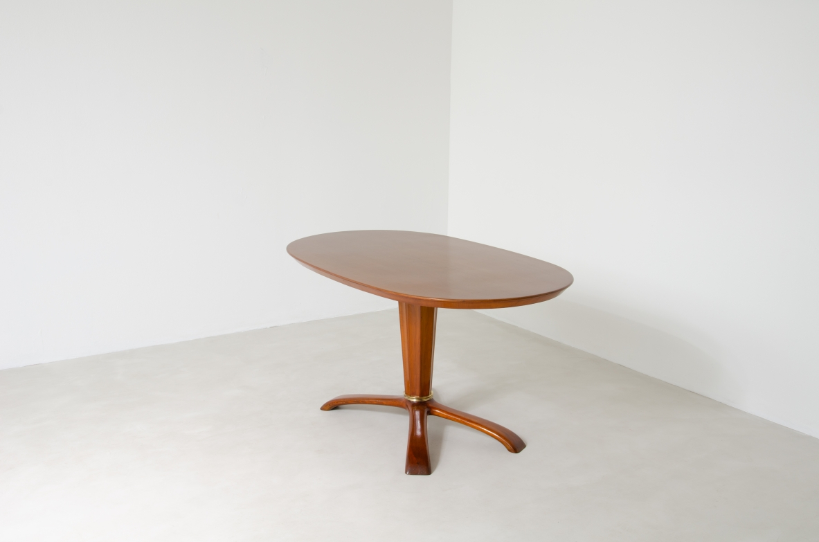 Osvaldo Borsani, tavolo in ciliegio con piano ovale, base a quattro razze e colonna centrale con anello in bronzo, 1950ca.