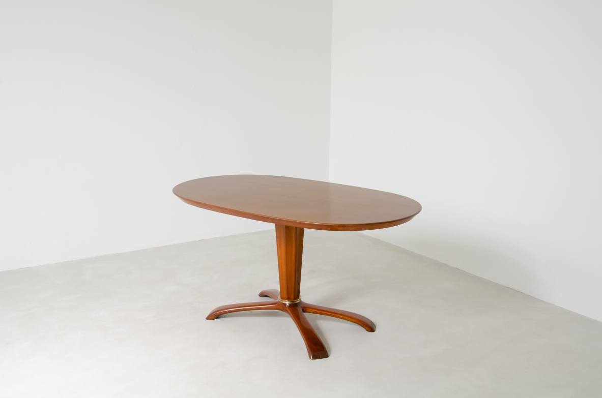 Osvaldo Borsani, tavolo in ciliegio con piano ovale, base a quattro razze e colonna centrale con anello in bronzo, 1950ca.