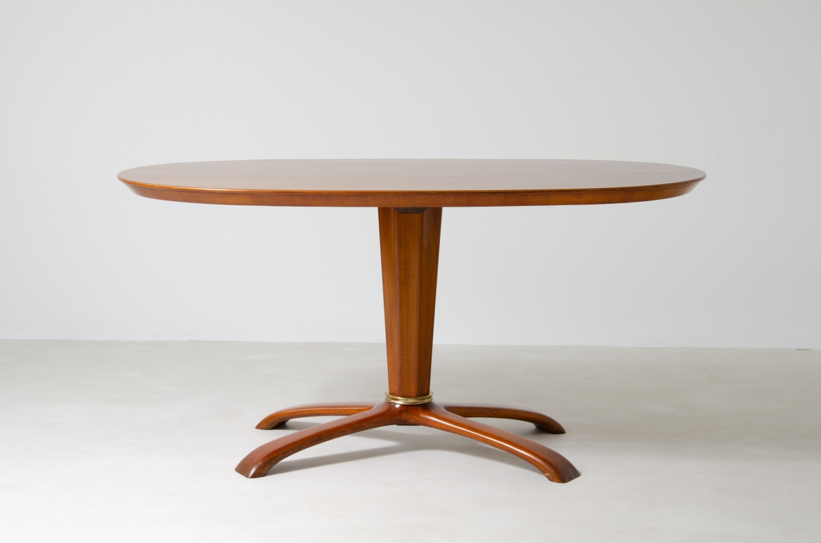 Osvaldo Borsani, tavolo in ciliegio con piano ovale, base a quattro razze e colonna centrale con anello in bronzo, 1950ca.