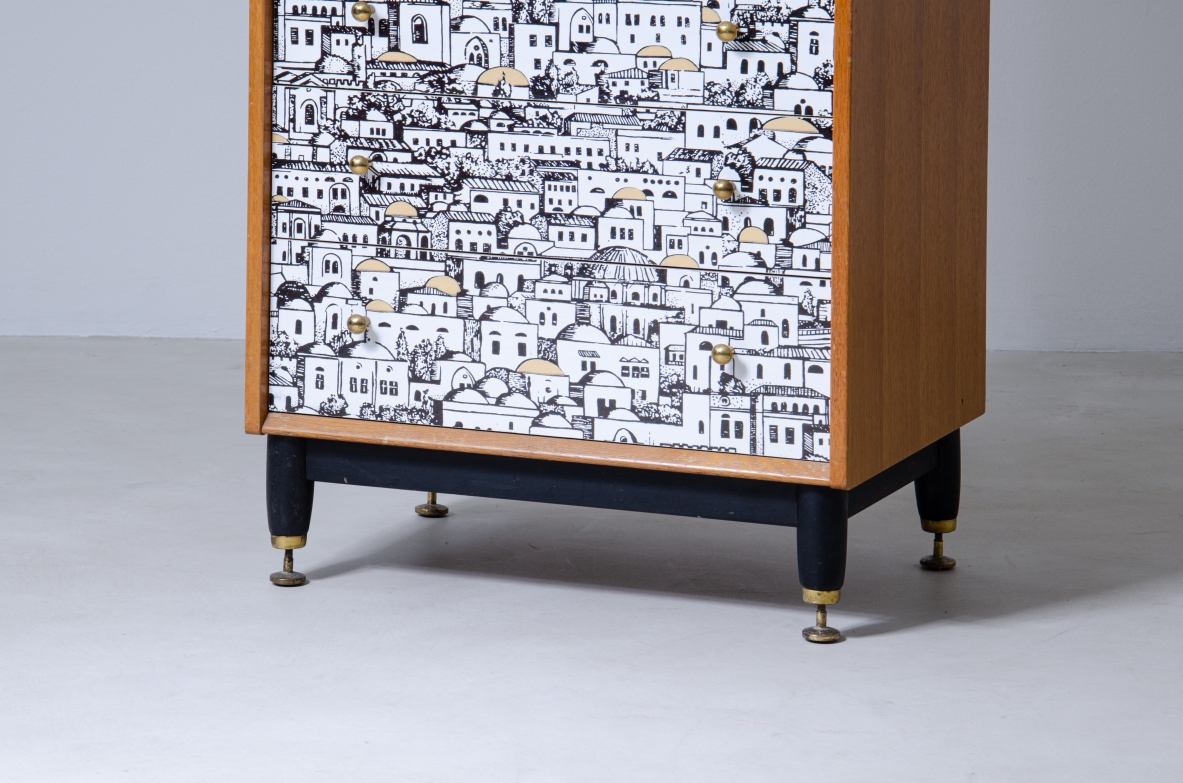 Piero Fornasetti, piccolo mobile a cassetti con fronte decorato con disegni di architetture medio orientali. Base in legno con puntali in ottone e fianchi in frassino.  Firmato Piero Fornasetti, 1950ca.