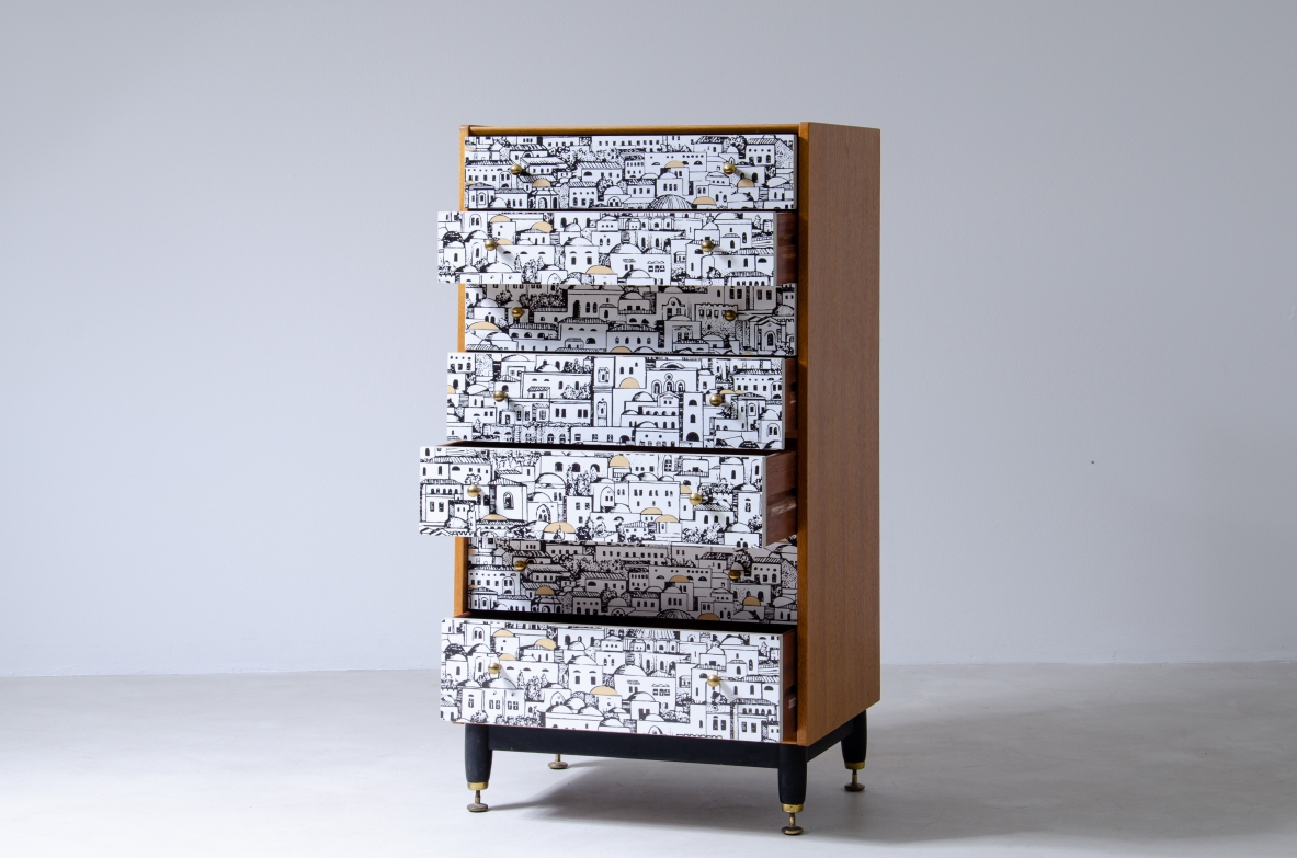 Piero Fornasetti, piccolo mobile a cassetti con fronte decorato con disegni di architetture medio orientali. Base in legno con puntali in ottone e fianchi in frassino.  Firmato Piero Fornasetti, 1950ca.