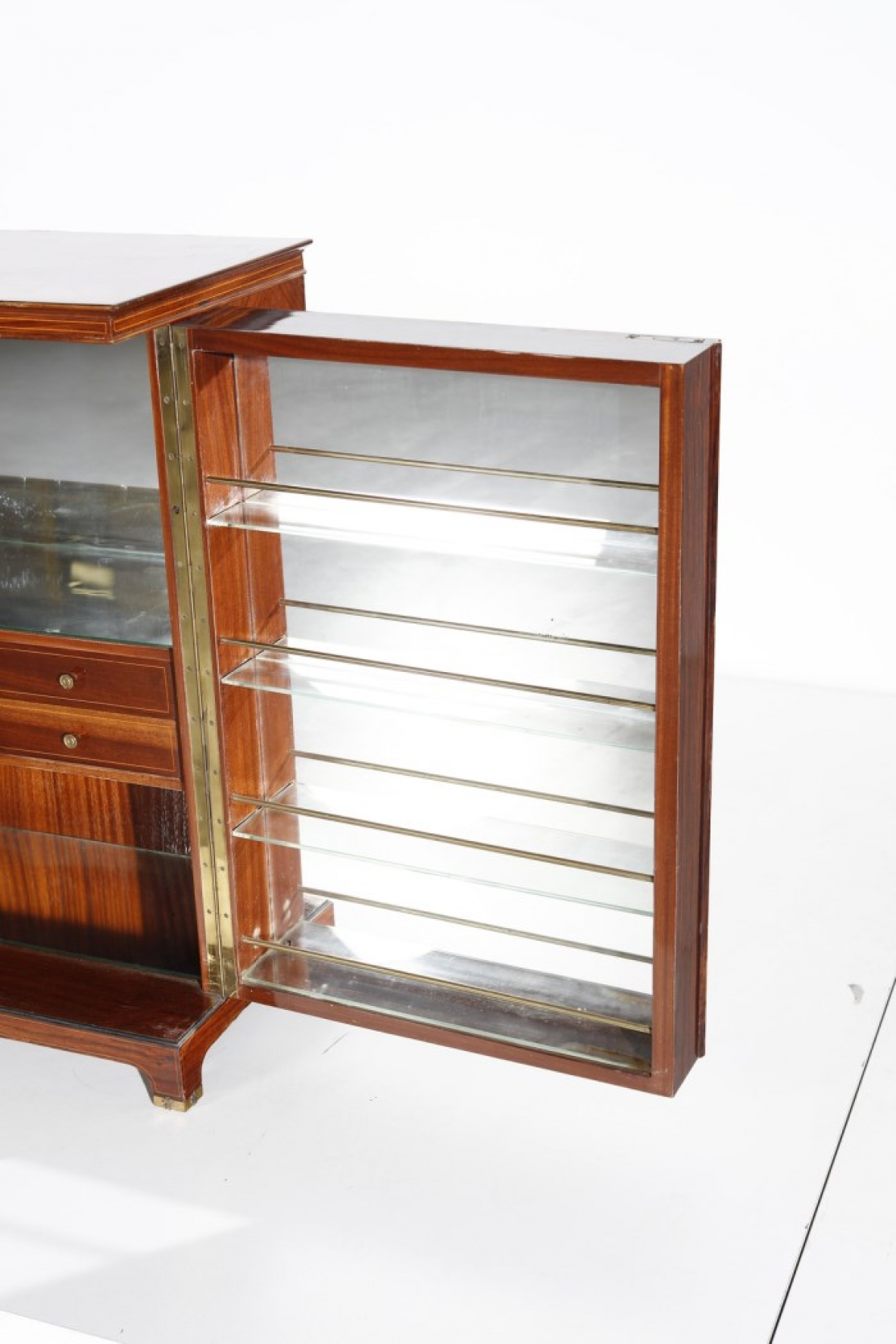 Paolo Buffa (1903-1970)  Elegante mobile bar con fronte in palissandro intarsiato e specchiature color ambra. All'interno ripiani e cassetti con scomparti e portabottiglie rivestiti in specchio. Dettagli in ottone.  Manifattura Italiana, 1940ca.