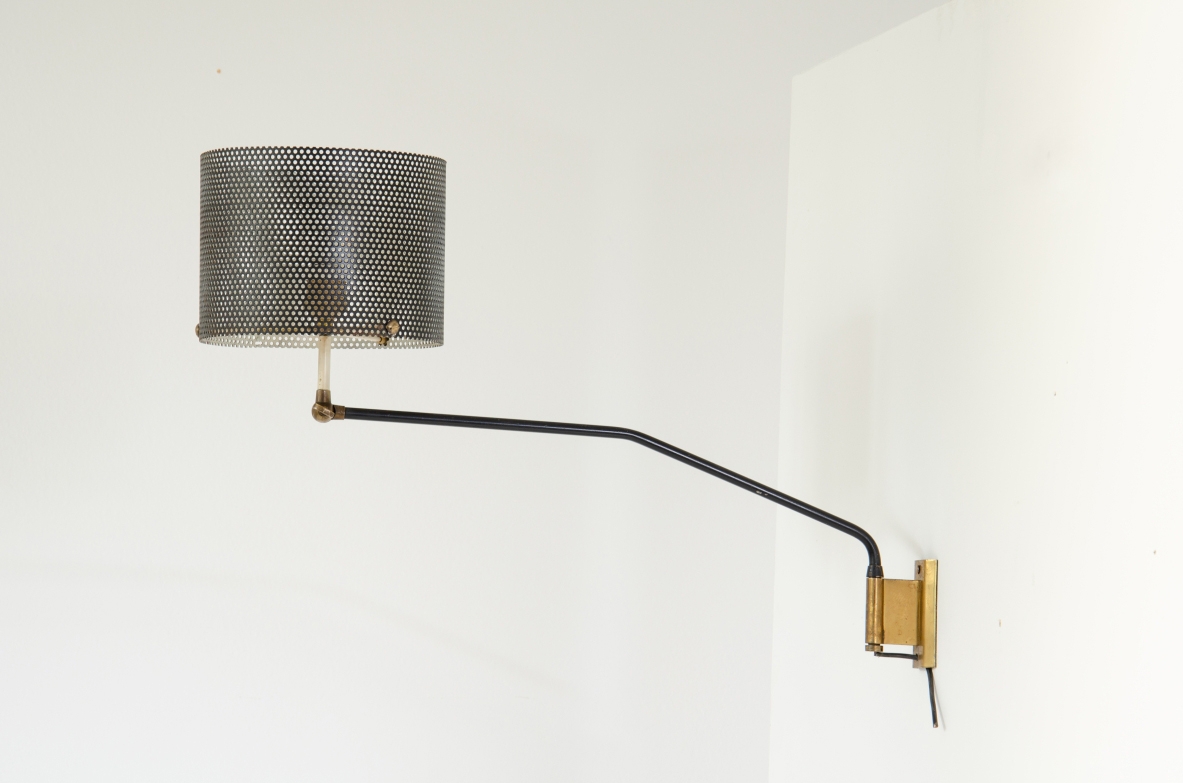 Stilnovo, 1950's wall lamp with adjustable arm and metal grid lampshade. Brass details.  Stamp of the manufacturer.