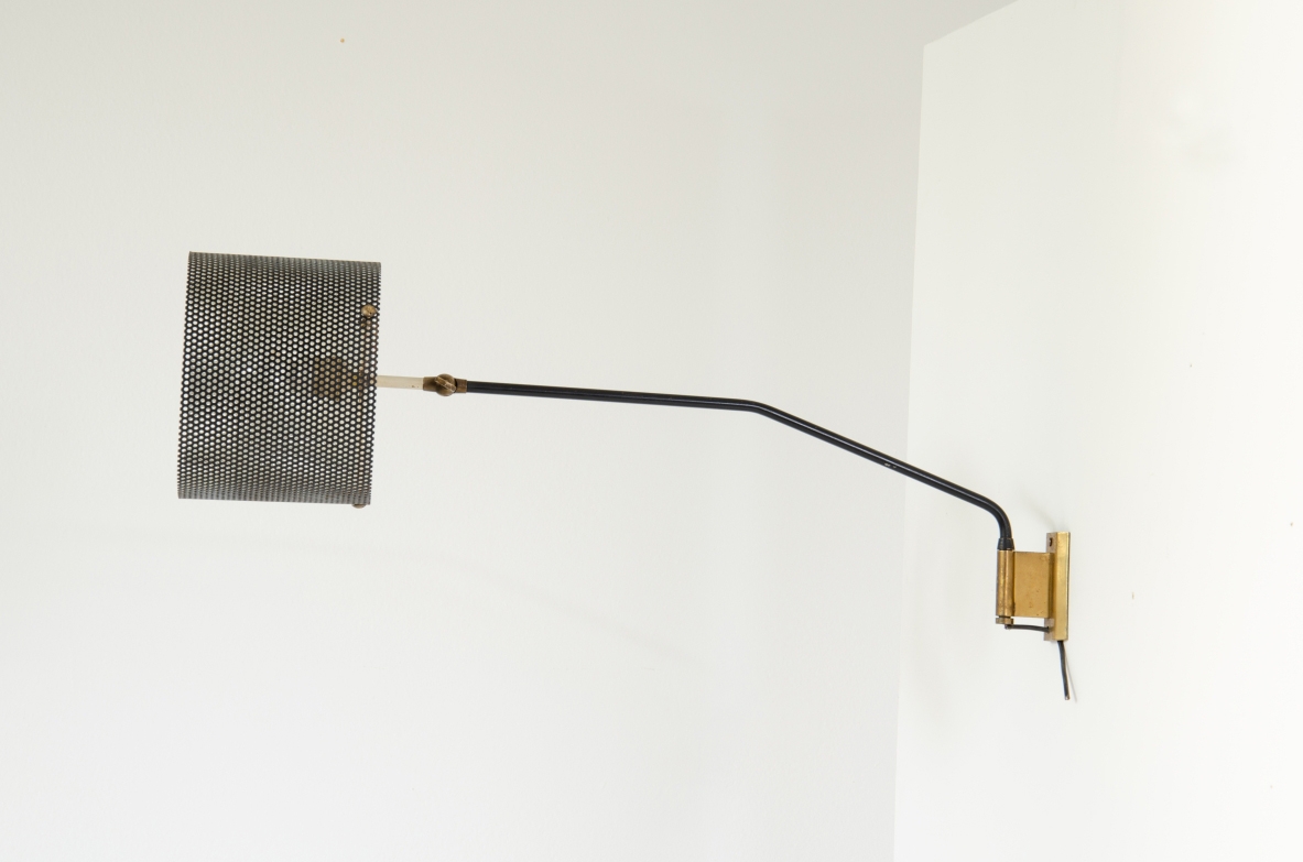 Stilnovo, 1950's wall lamp with adjustable arm and metal grid lampshade. Brass details.  Stamp of the manufacturer.