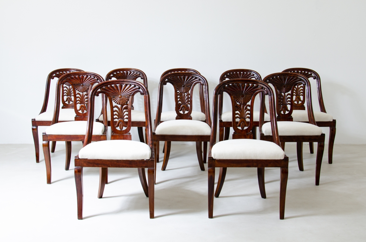 Raro set di 12 sedie in noce a pozzetto con schienale intagliato.  Epoca Carlo X, Italia, Lombardia, 1830ca.