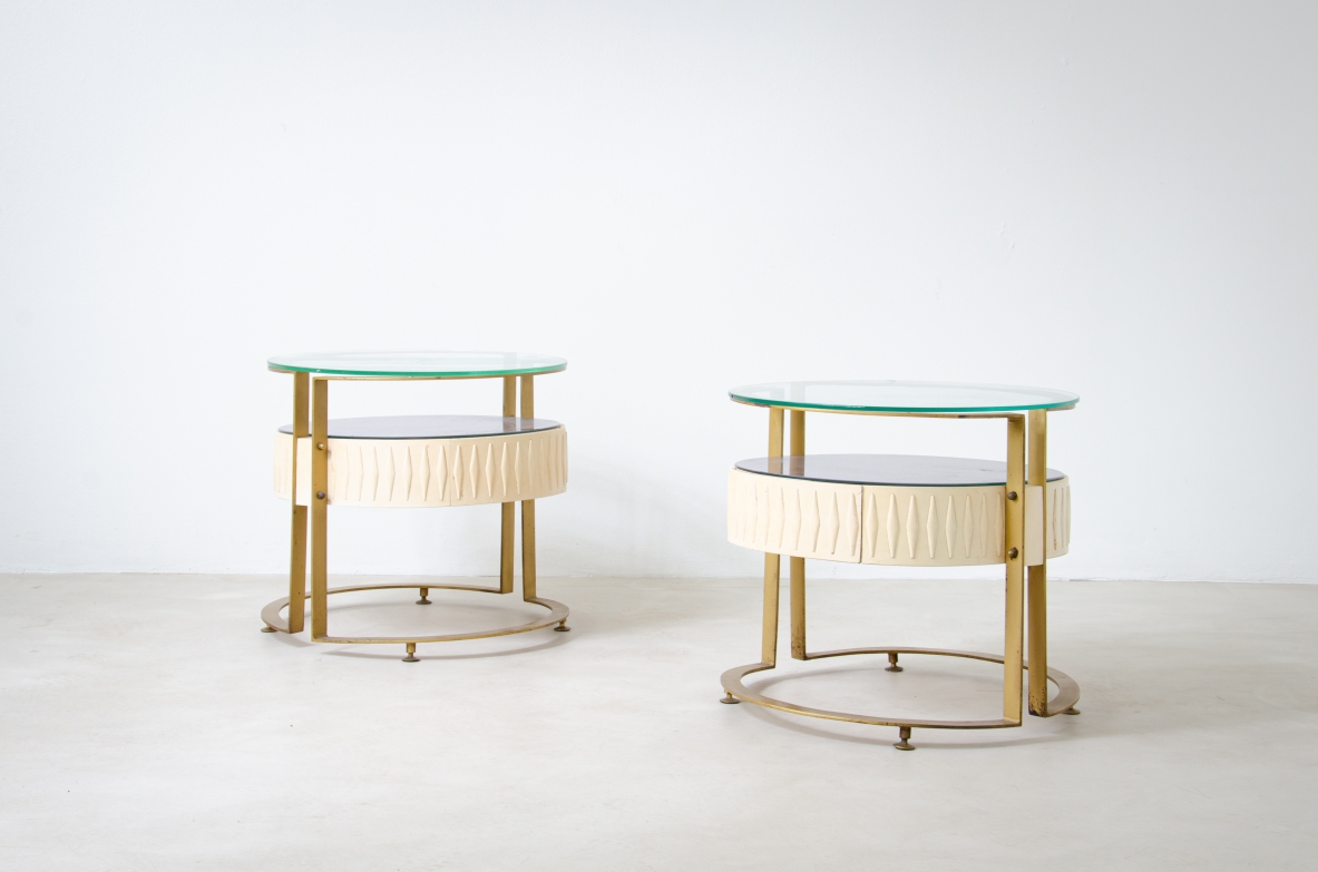 Coppia di comodini di forma ovale con struttura in metallo e legno laccato, doppio piano in vetro. Manifattura italiana, 1960ca.