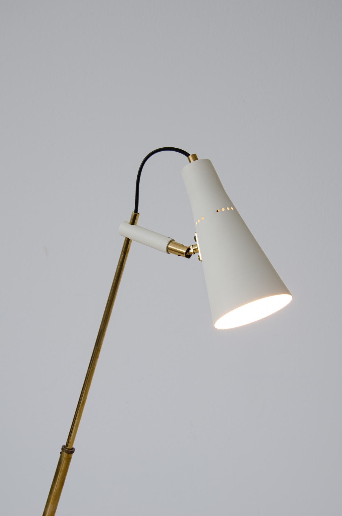 Lampada da terra con stelo in ottone a telescopio orientabile in tutte le direzioni. Cono e base in metallo laccato.  Nello stile di un modello disegnato da Giuseppe Ostuni per Oluce, 1950ca.