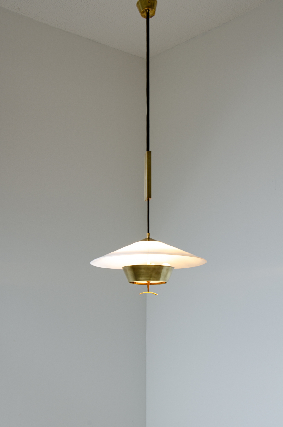Stilnovo  Lampadario saliscendi con contrappeso in ottone, diffusore in perspex e ottone.  Manifattura 1960ca