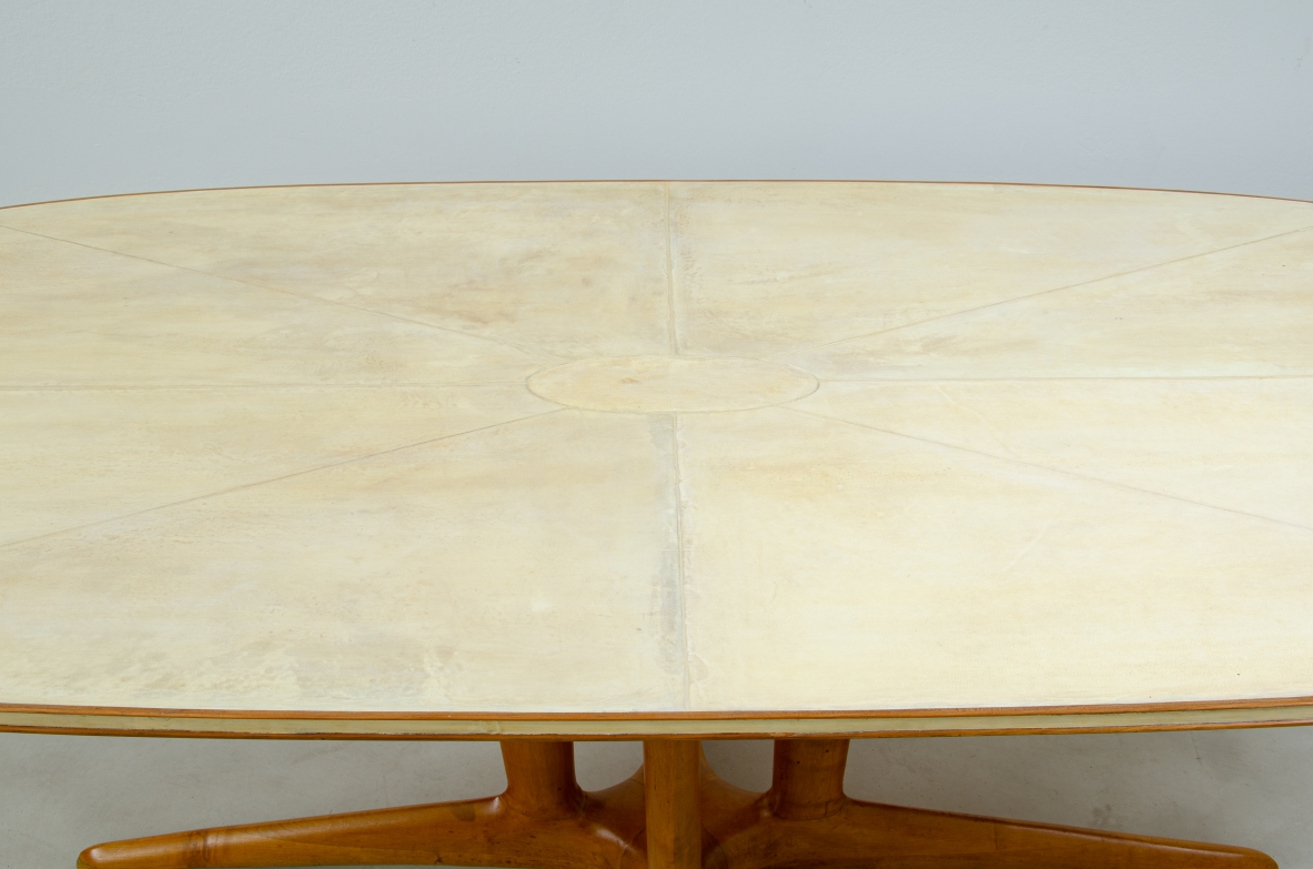Grande tavolo con elegante struttura in legno biondo e piano rivestito in pergamena.  Manifattura italiana anni 50.