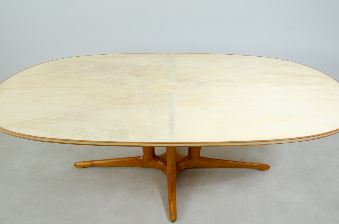Grande tavolo con elegante struttura in legno biondo e piano rivestito in pergamena.  Manifattura italiana anni 50.