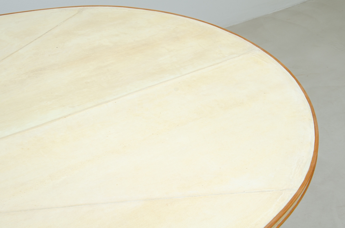 Grande tavolo con elegante struttura in legno biondo e piano rivestito in pergamena.  Manifattura italiana anni 50.