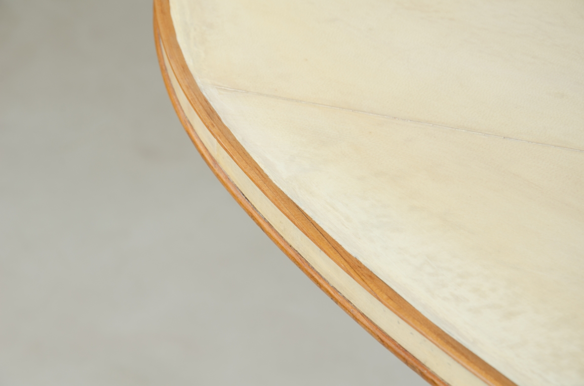 Grande tavolo con elegante struttura in legno biondo e piano rivestito in pergamena.  Manifattura italiana anni 50.