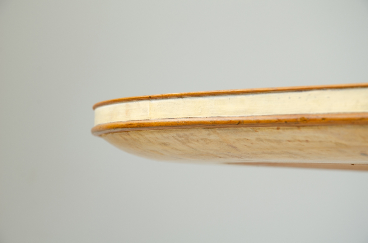 Grande tavolo con elegante struttura in legno biondo e piano rivestito in pergamena.  Manifattura italiana anni 50.