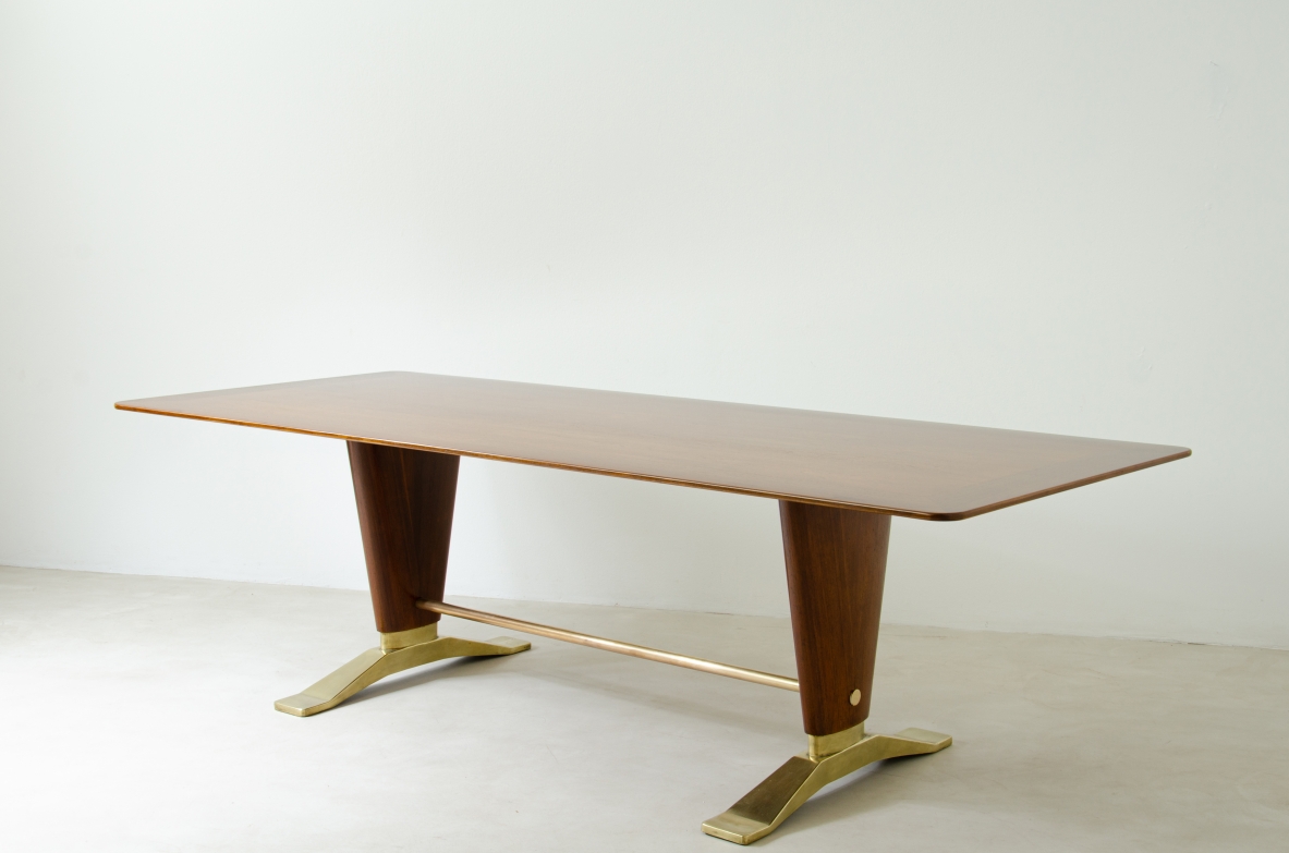 Grande tavolo in legno di noce con due montanti tenuti da traversa in ottone e importanti basamenti in fusione di bronzo.  Manifattura italiana 1940ca.