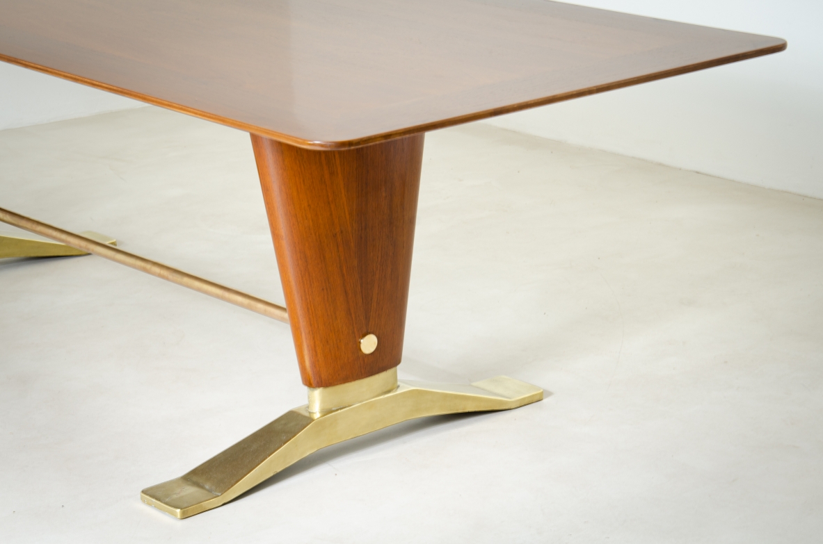 Grande tavolo in legno di noce con due montanti tenuti da traversa in ottone e importanti basamenti in fusione di bronzo.  Manifattura italiana 1940ca.