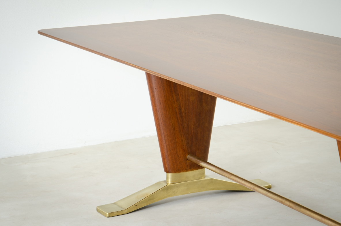 Grande tavolo in legno di noce con due montanti tenuti da traversa in ottone e importanti basamenti in fusione di bronzo.  Manifattura italiana 1940ca.