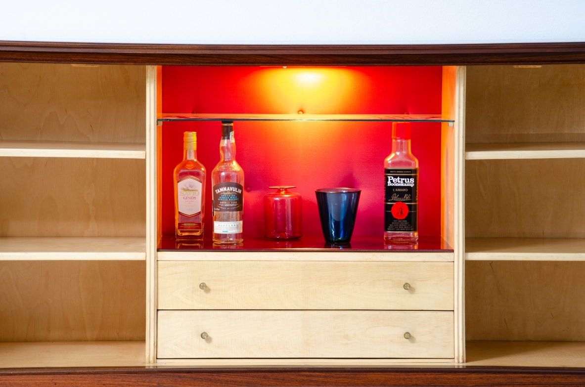 A large 1950's sideboard designed by Osvaldo Borsani for Arredamenti Borsani Varedo. Grinded mahogany, gilded bronze handles by Lucio Fontana, interior illumination.
