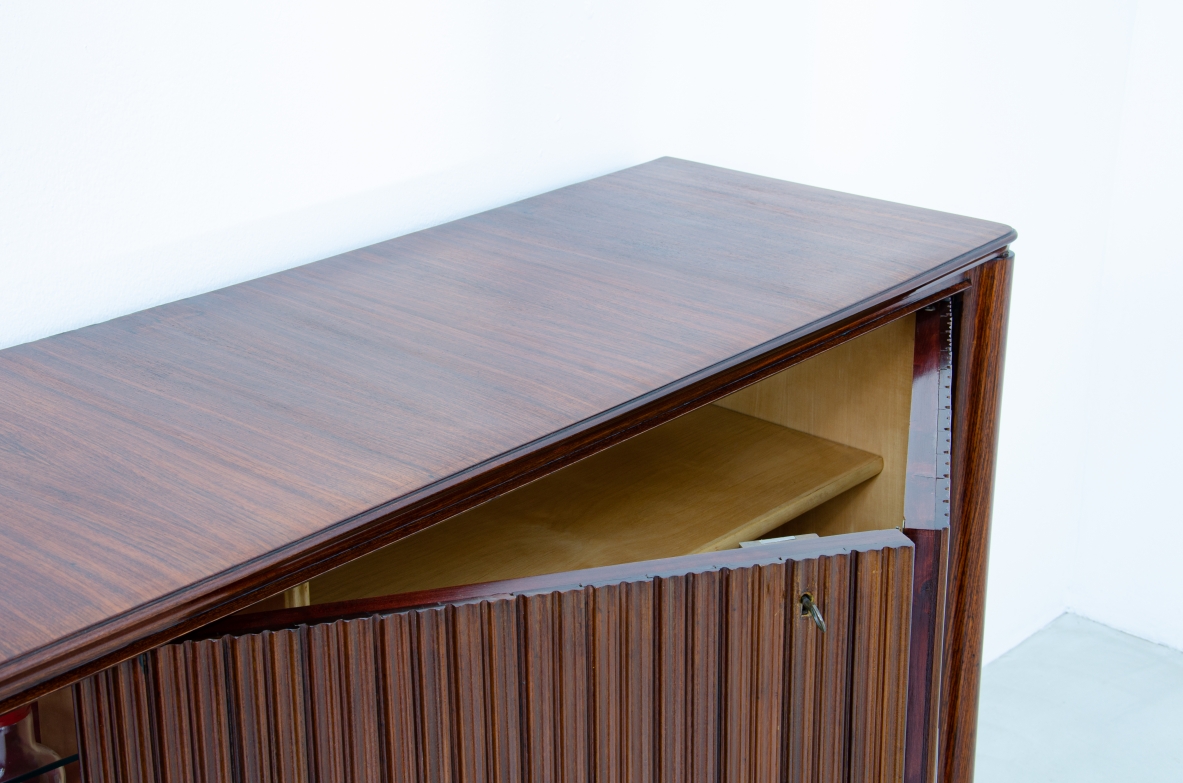 A large 1950's sideboard designed by Osvaldo Borsani for Arredamenti Borsani Varedo. Grinded mahogany, gilded bronze handles by Lucio Fontana, interior illumination.