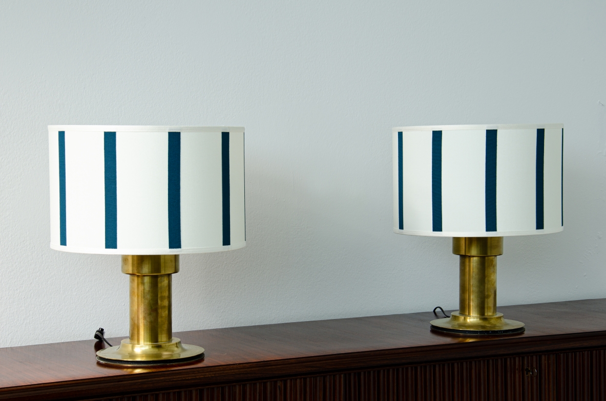 Coppia di lampade da tavolo con fusto a cilindro in ottone e cappello in tessuto. Manifattura italiana 1970ca.