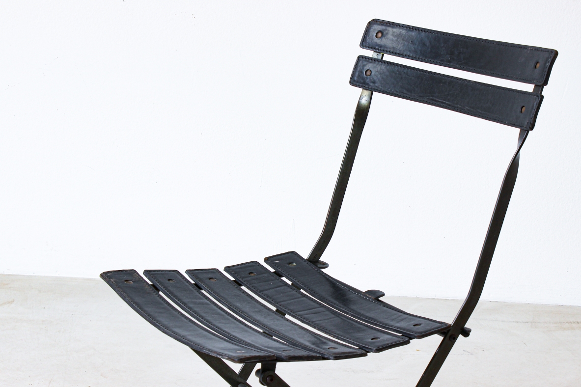 Sedia pieghevole in ferro con rivestimento in pelle nera. Manifattura italiana, 1970ca.
