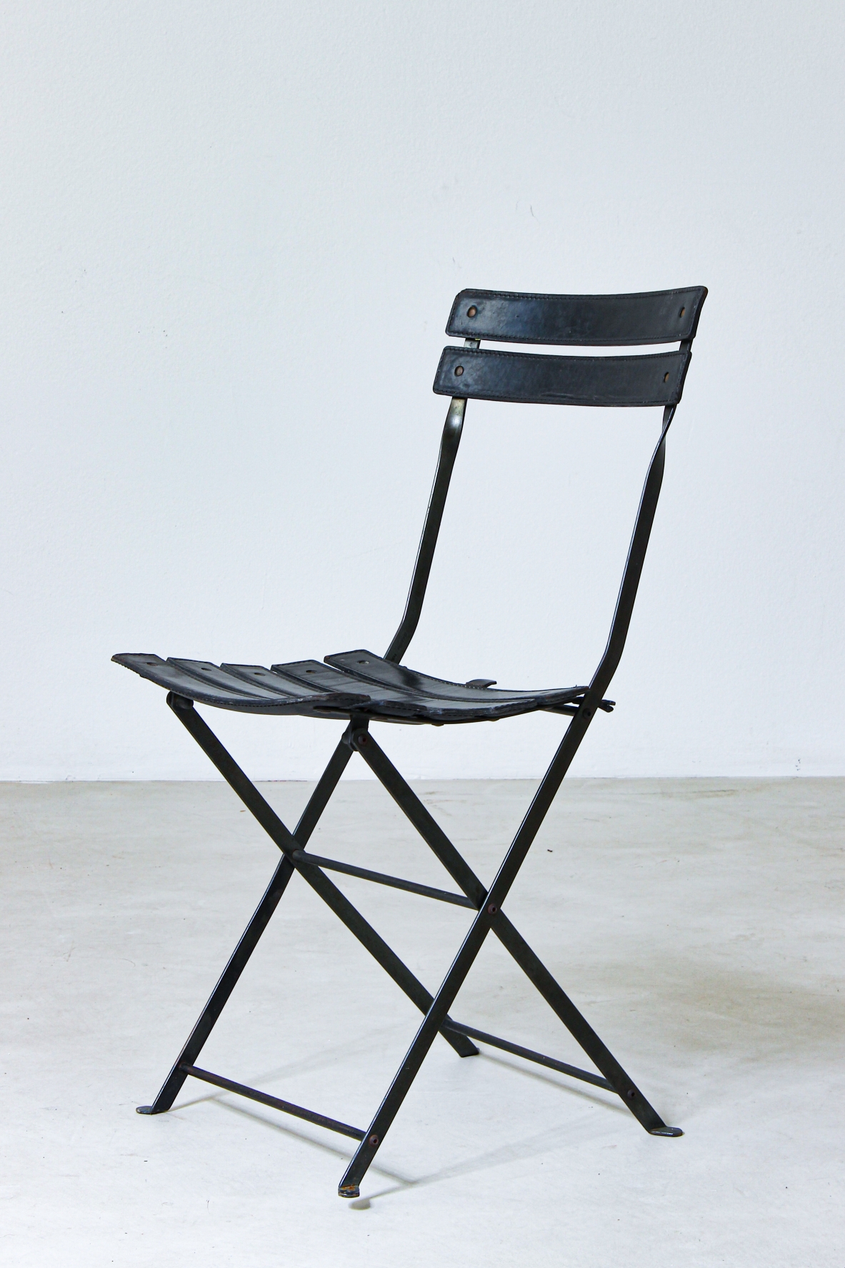 Sedia pieghevole in ferro con rivestimento in pelle nera. Manifattura italiana, 1970ca.
