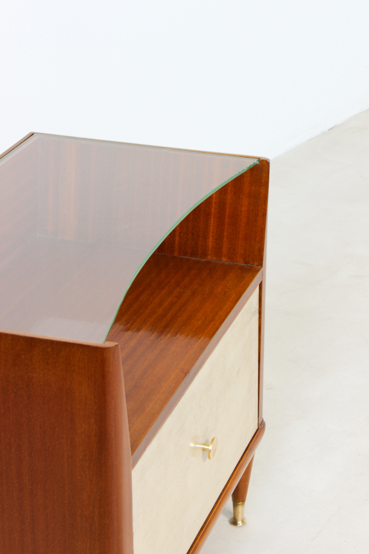 Paolo Buffa (1903 - 1970)  Coppia di comodini con fronte in pergamena e piano in cristallo molato, puntali in ottone e un cassetto all'interno.  Manifattura italiana, 1950ca