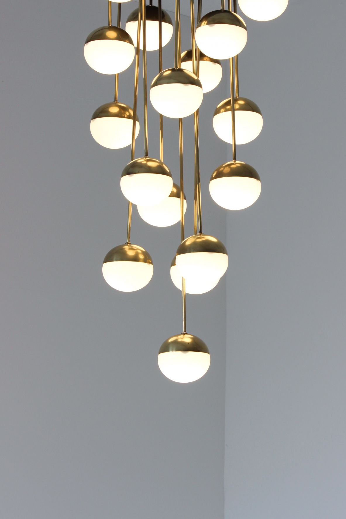 Stilnovo. Grande lampadario a 18 luci con struttura in ottone e vetri opaline. 1960ca.