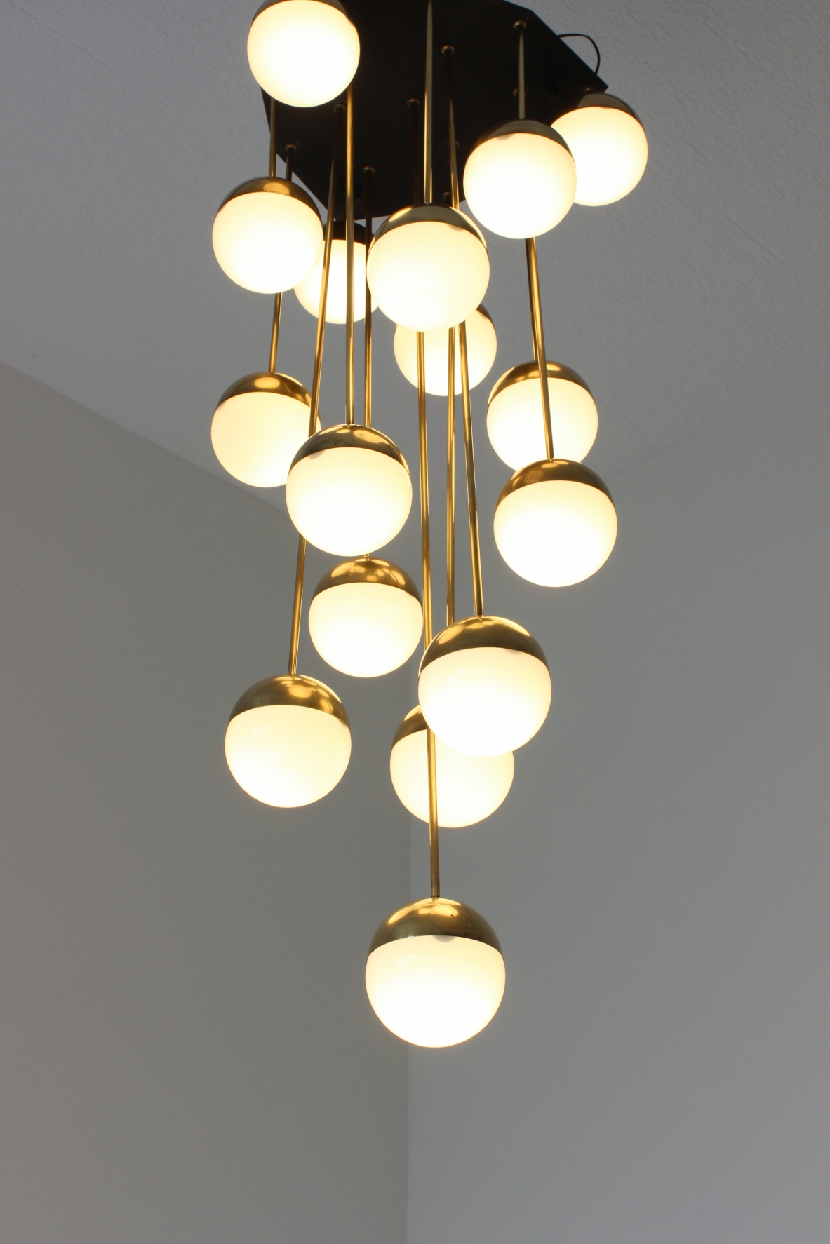 Stilnovo. Grande lampadario a 18 luci con struttura in ottone e vetri opaline. 1960ca.