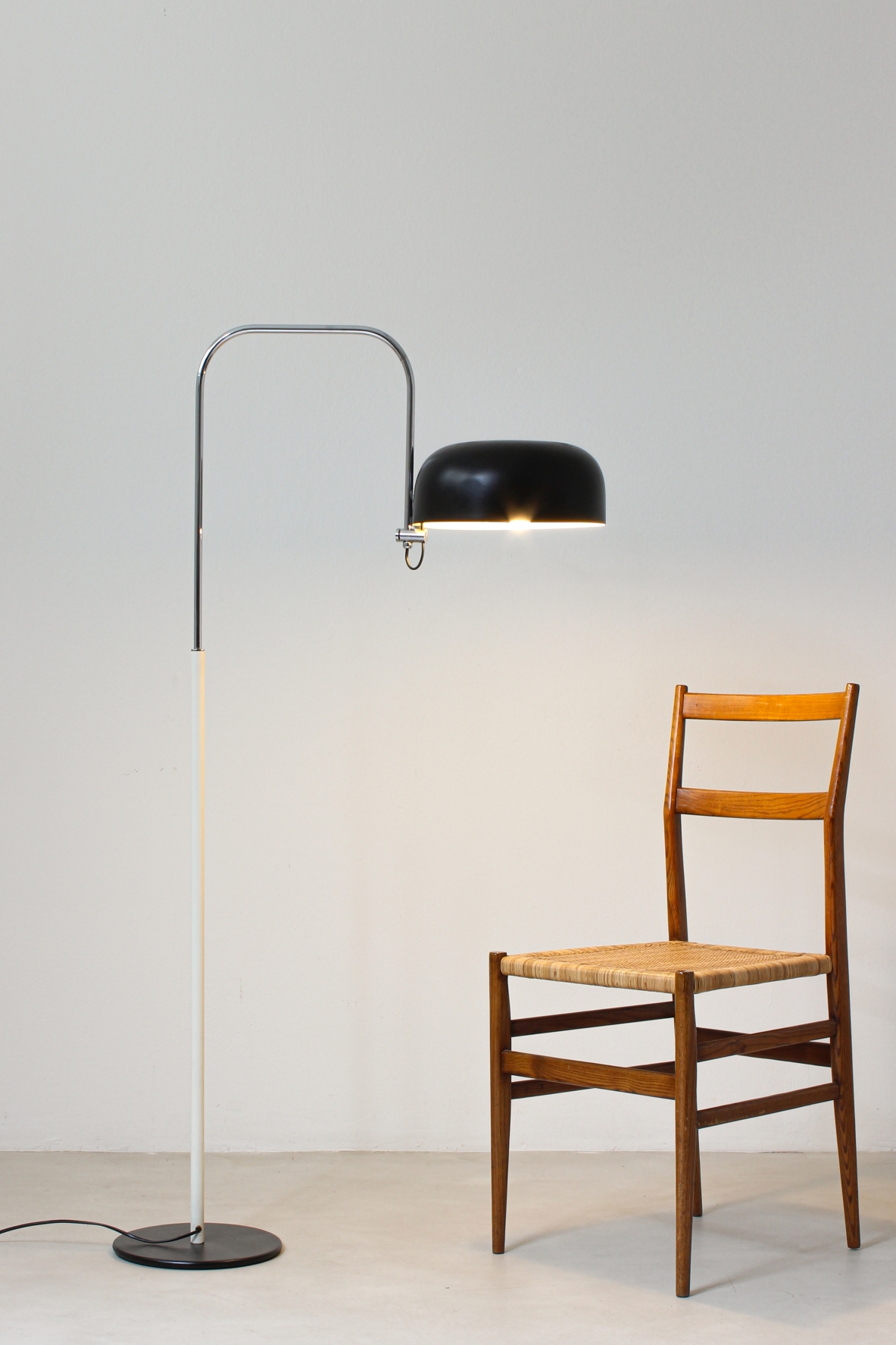 Reading lamp in black and white lacquered metal with curved chromed metal stem.