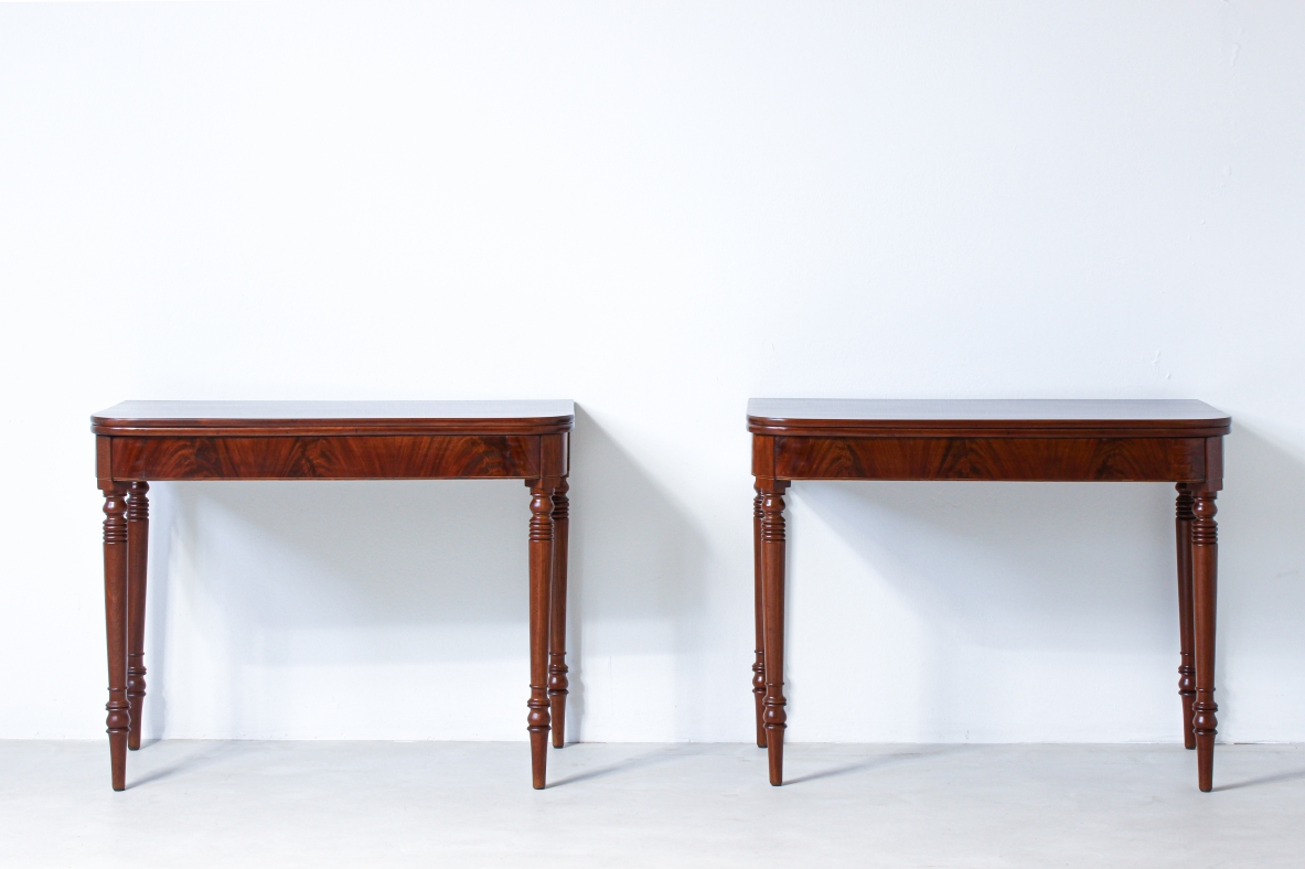 Pair of elegant consoles in mahogany with double book top and turned legs.
