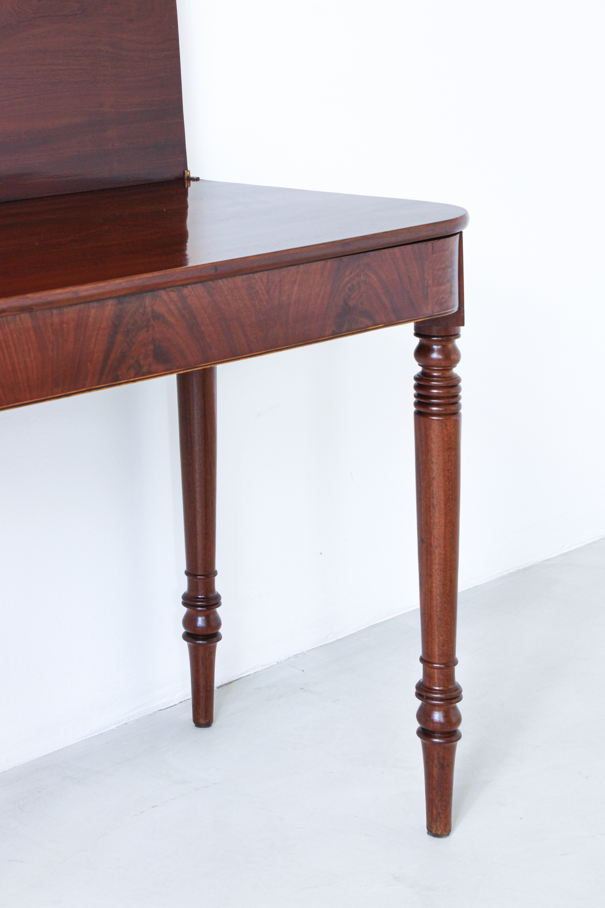 Pair of elegant consoles in mahogany with double book top and turned legs.