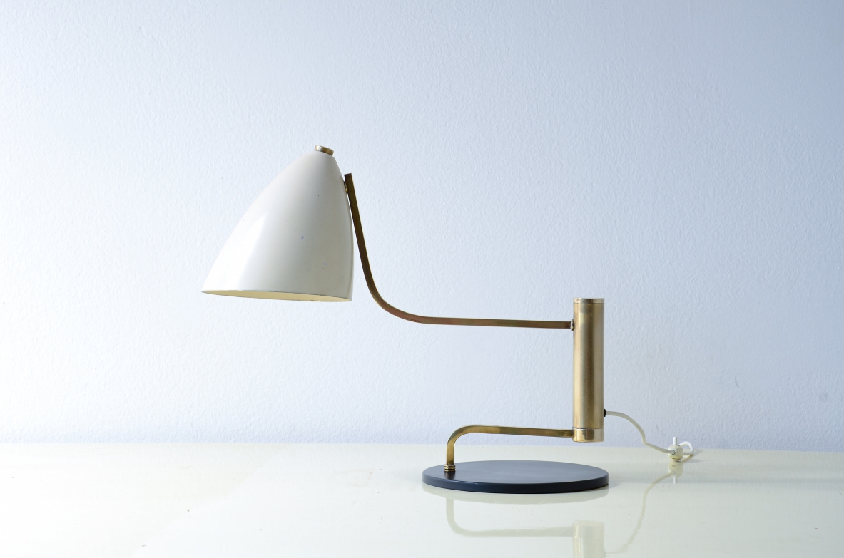 Lampada da tavolo in metallo e ottone con braccio snodabile in ottone e cappello in metallo verniciato.  Manifattura Italiana, 1950ca.