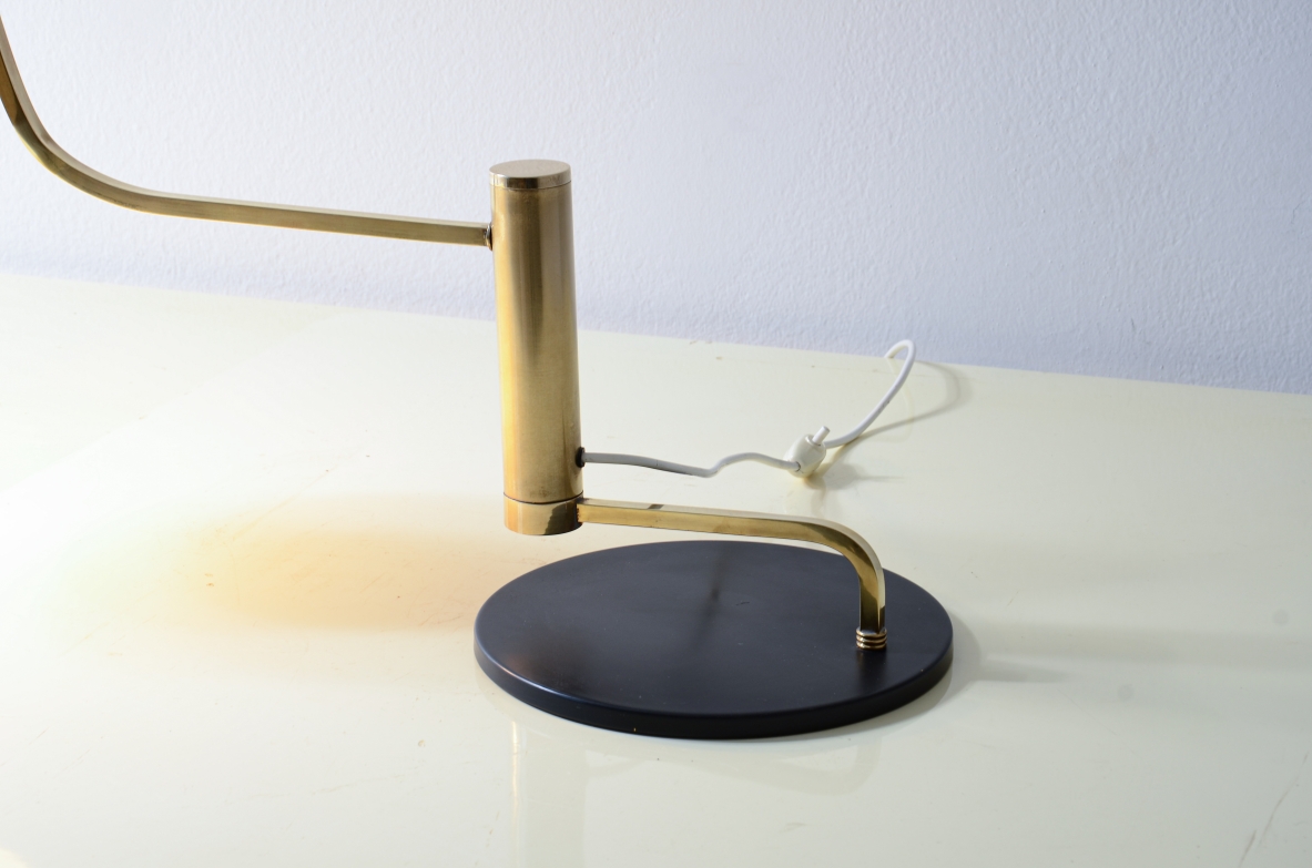 Lampada da tavolo in metallo e ottone con braccio snodabile in ottone e cappello in metallo verniciato.  Manifattura Italiana, 1950ca.