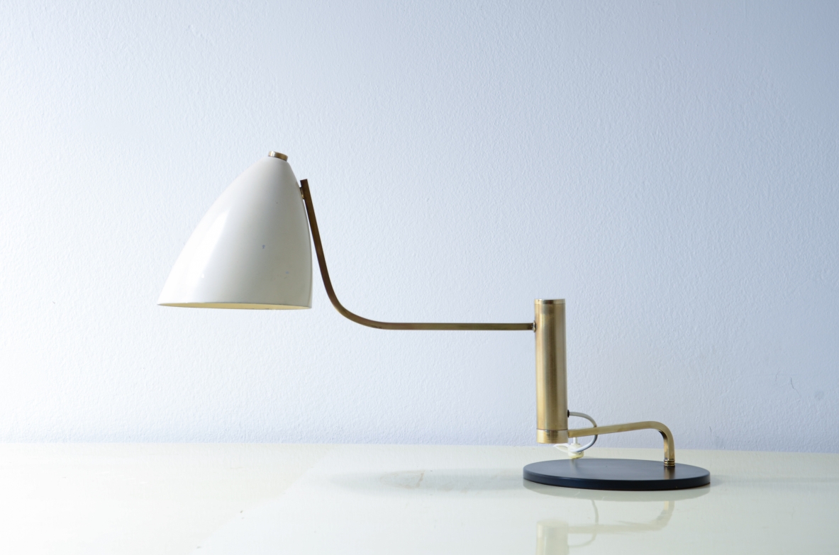 Lampada da tavolo in metallo e ottone con braccio snodabile in ottone e cappello in metallo verniciato.  Manifattura Italiana, 1950ca.