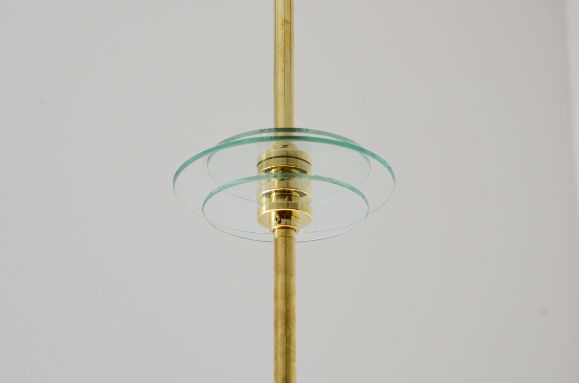 Grande lampadario in ottone con vetro molato e decorato con i disegni dello zodiaco e due vetri bianco lattimo. Stelo in ottone con tre dischi in vetro trasparente molato.  Manifattura Brusotti Milano, 1930-40ca.