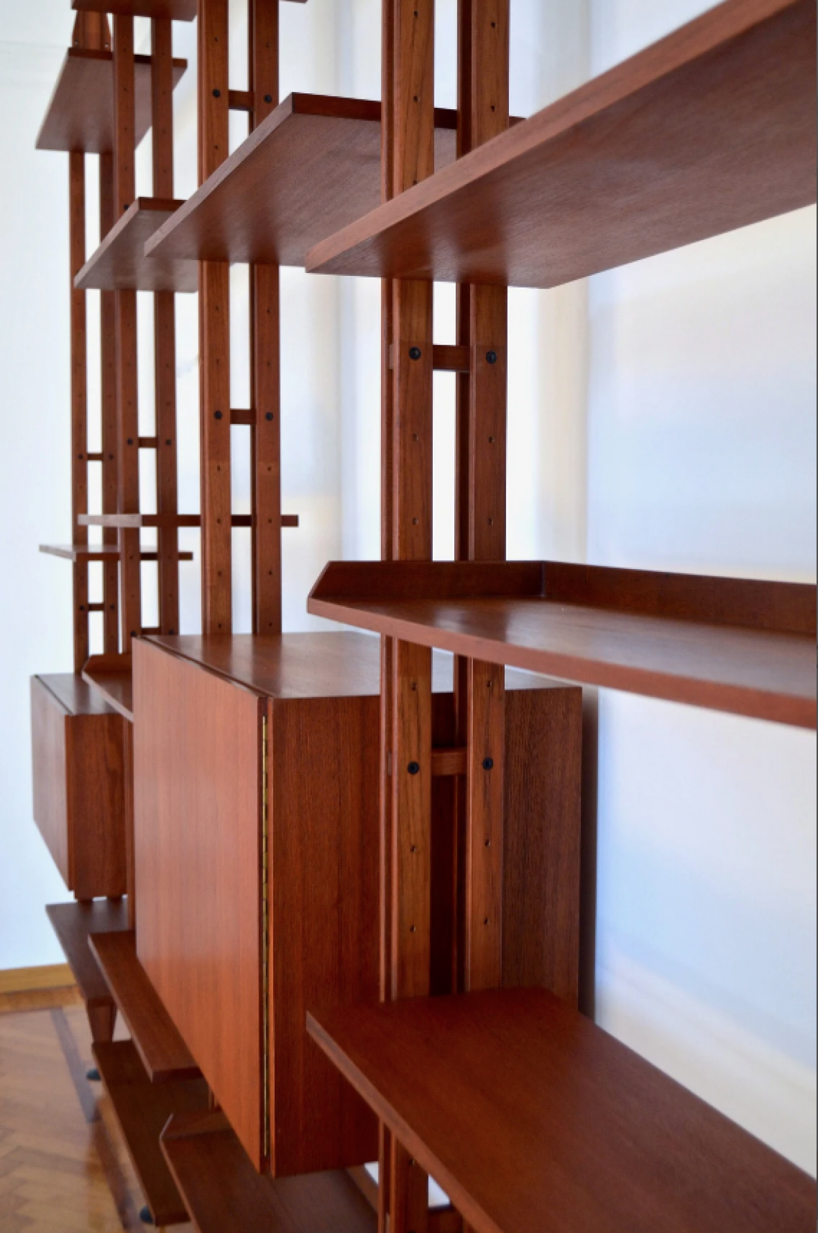 Franco Albini, Libreria Infinito.Grande libreria modulare composta da 6 montanti verticali, elementi contenitori con ante a battente e ante inferiori 22 ripiani in tek