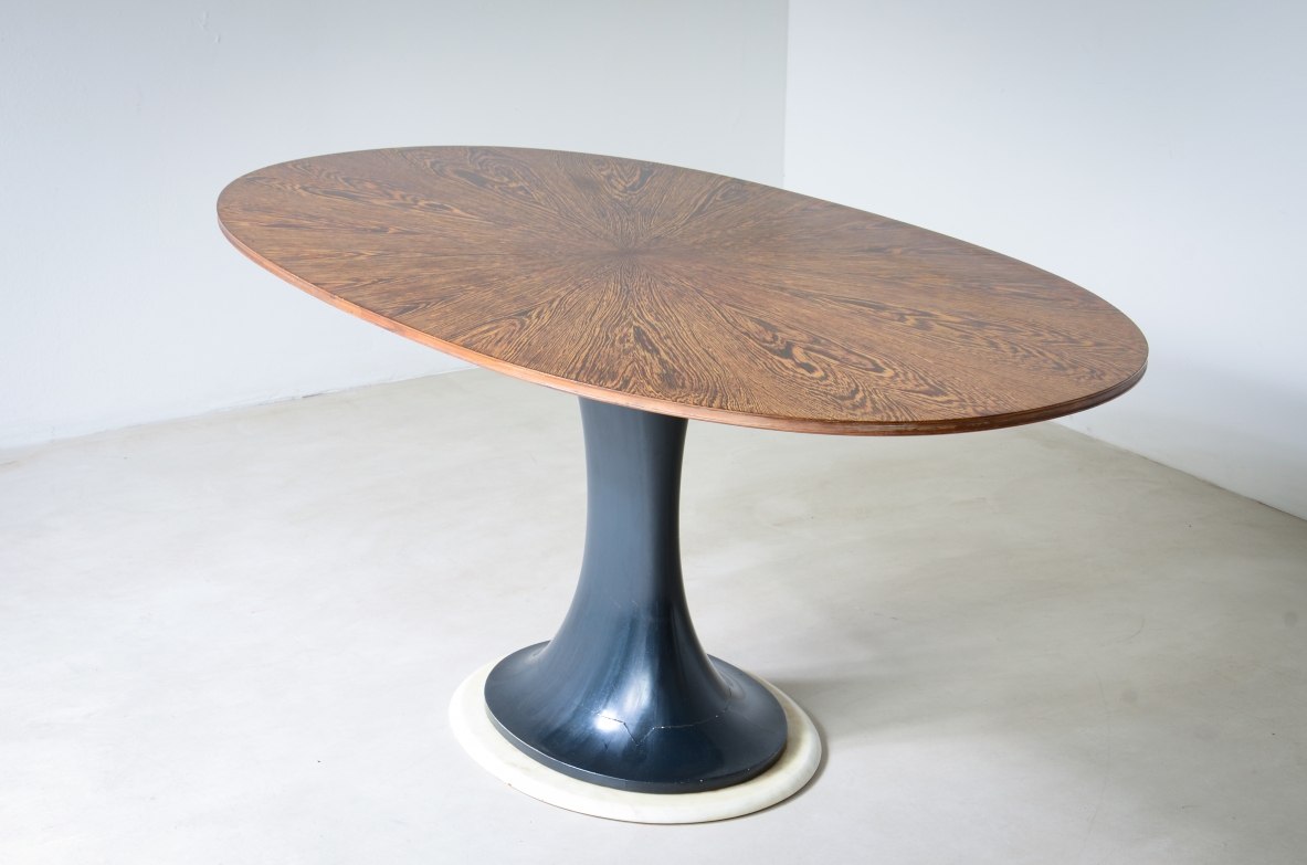 Elegante tavolo ovale con base tornita in legno laccato blu petrolio e disco in marmo, piano lastronato in legno di palma.  Scuola di Torino, 1960ca.