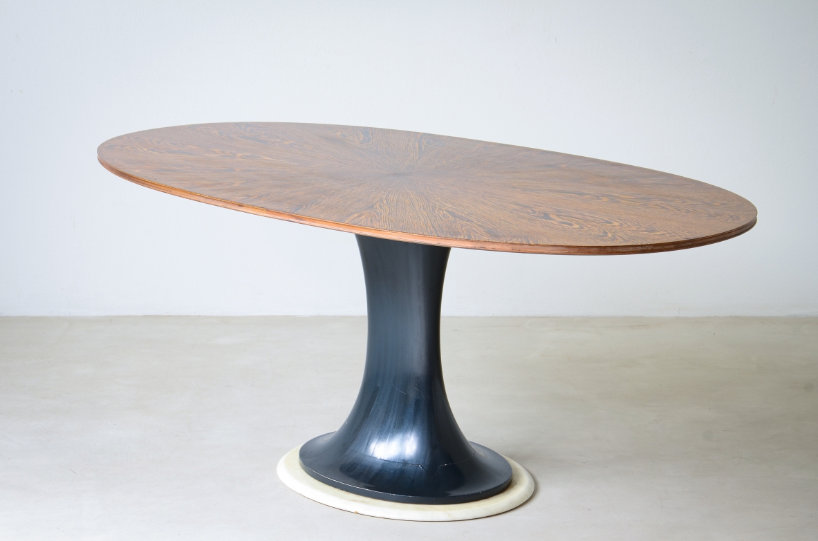 Elegante tavolo ovale con base tornita in legno laccato blu petrolio e disco in marmo, piano lastronato in legno di palma.  Scuola di Torino, 1960ca.