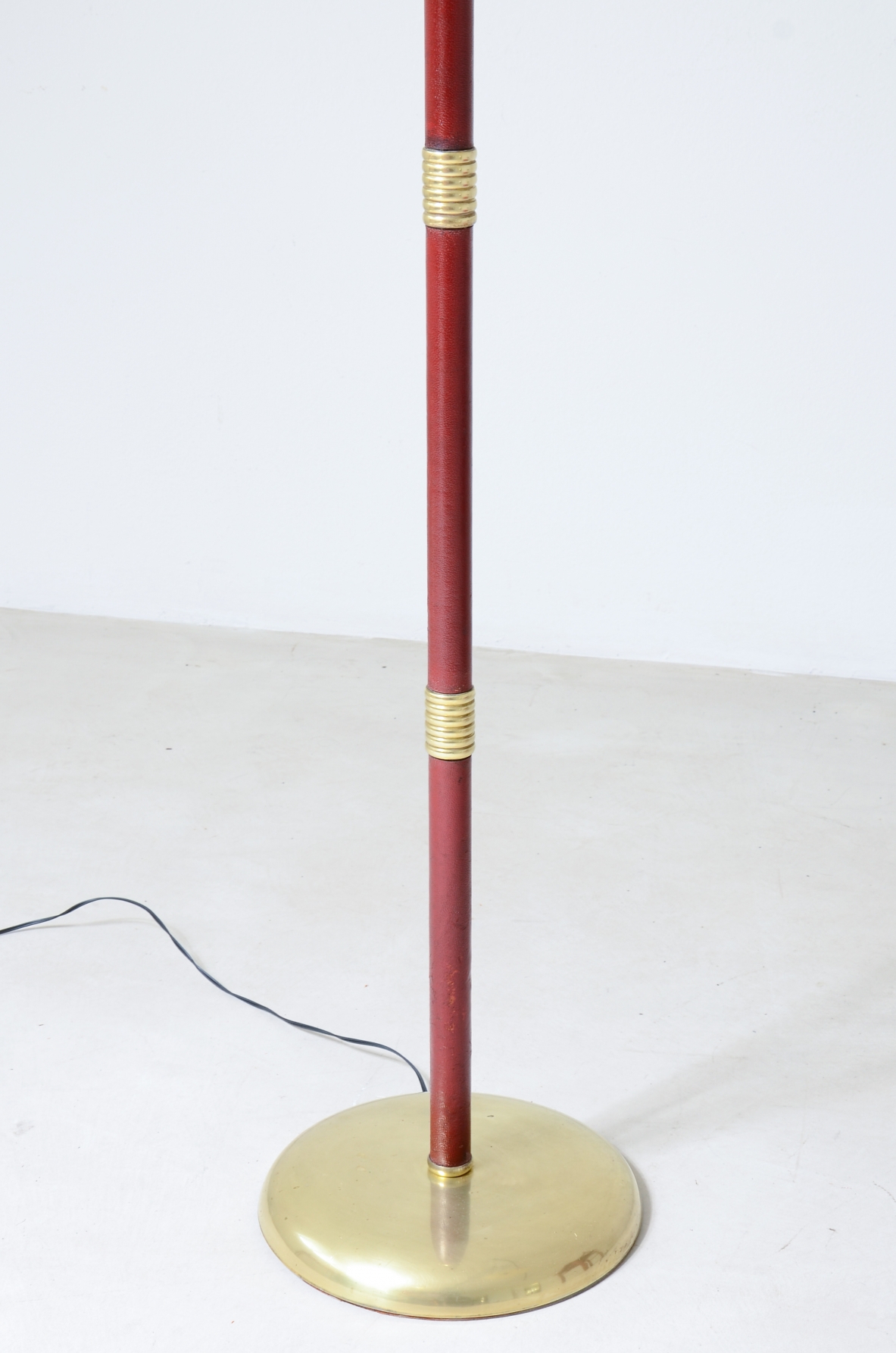 Lampada da terra con stelo snodabile in ottone e dettagli in pelle, elegante paralume in pergamena.  Manifattura italiana 1930ca.