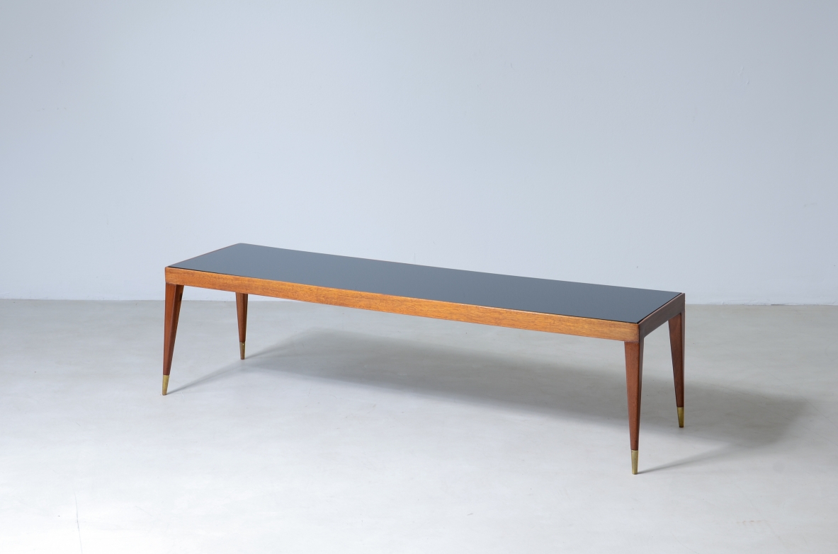 Elegante tavolo basso in mogano chiaro con puntali in ottone e piano in vetro.  Manifattura italiana, 1950ca.