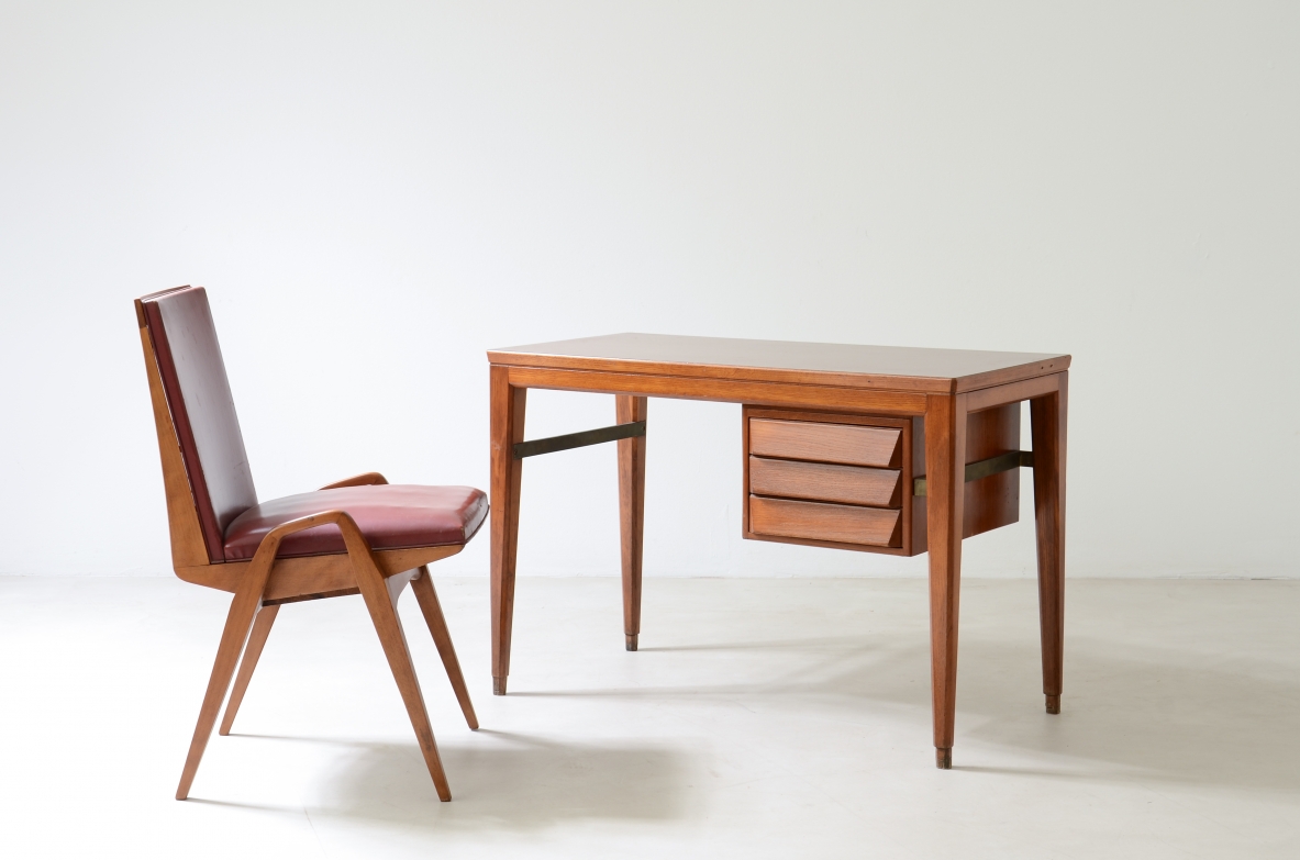 Gio Ponti  Elegante scrivania in rovere disegnata da Gio Ponti per la Banca Nazionale del Lavoro. Gambe leggermente curvate unite da un distanziale in ottone, tre cassetti con fronte sagomato.