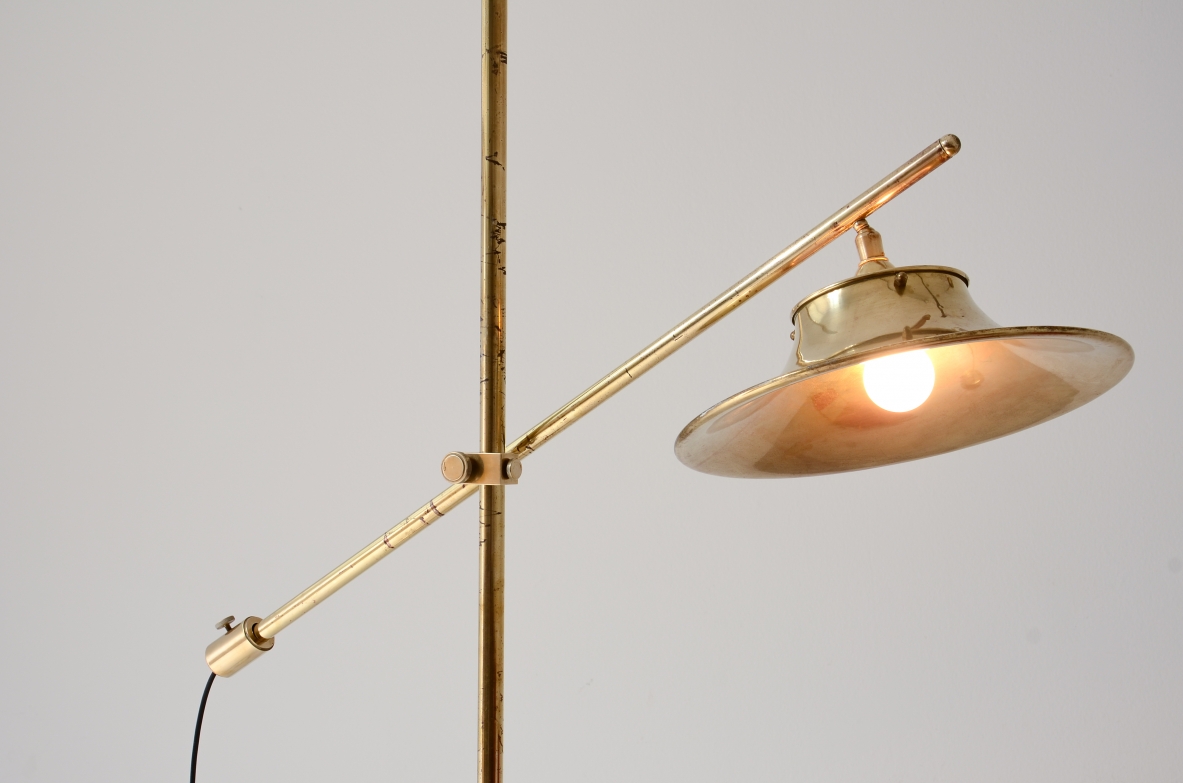 Lampada da terra in ottone con asta a bilanciere, base e cappello in ottone sagomato e forato.  Manifattura italiana, 1950ca.