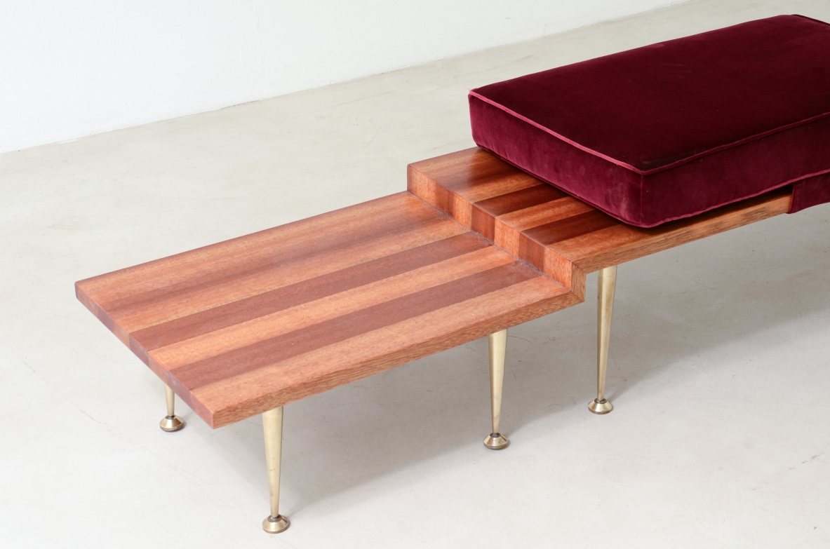 Large shaped wooden bench with eight turned brass feet and velvet-covered cushions.  Italian manufacture from the 1950s