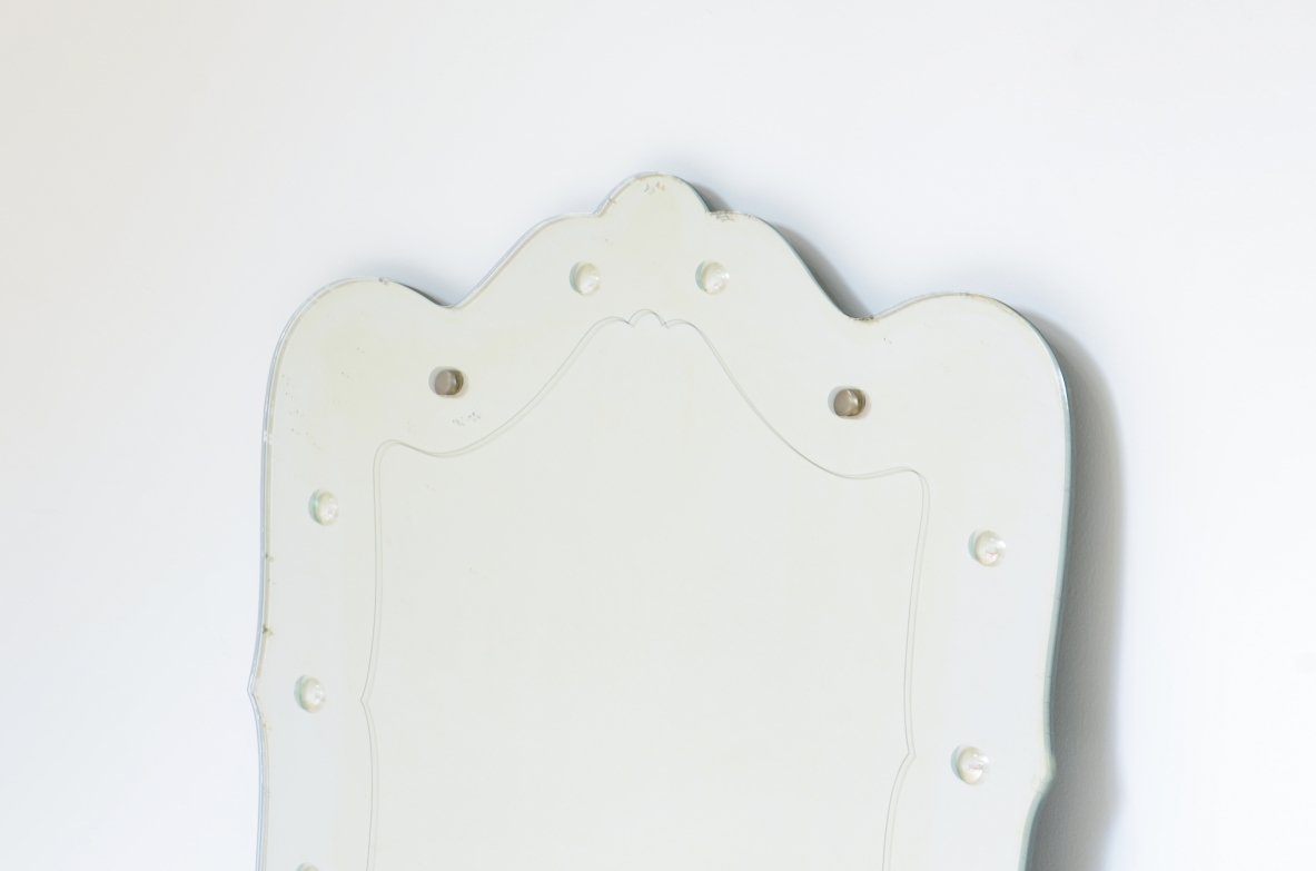 Specchiera sagomata con decoro a bottoni retro incisi.  Manifattura italiana anni 40ca.